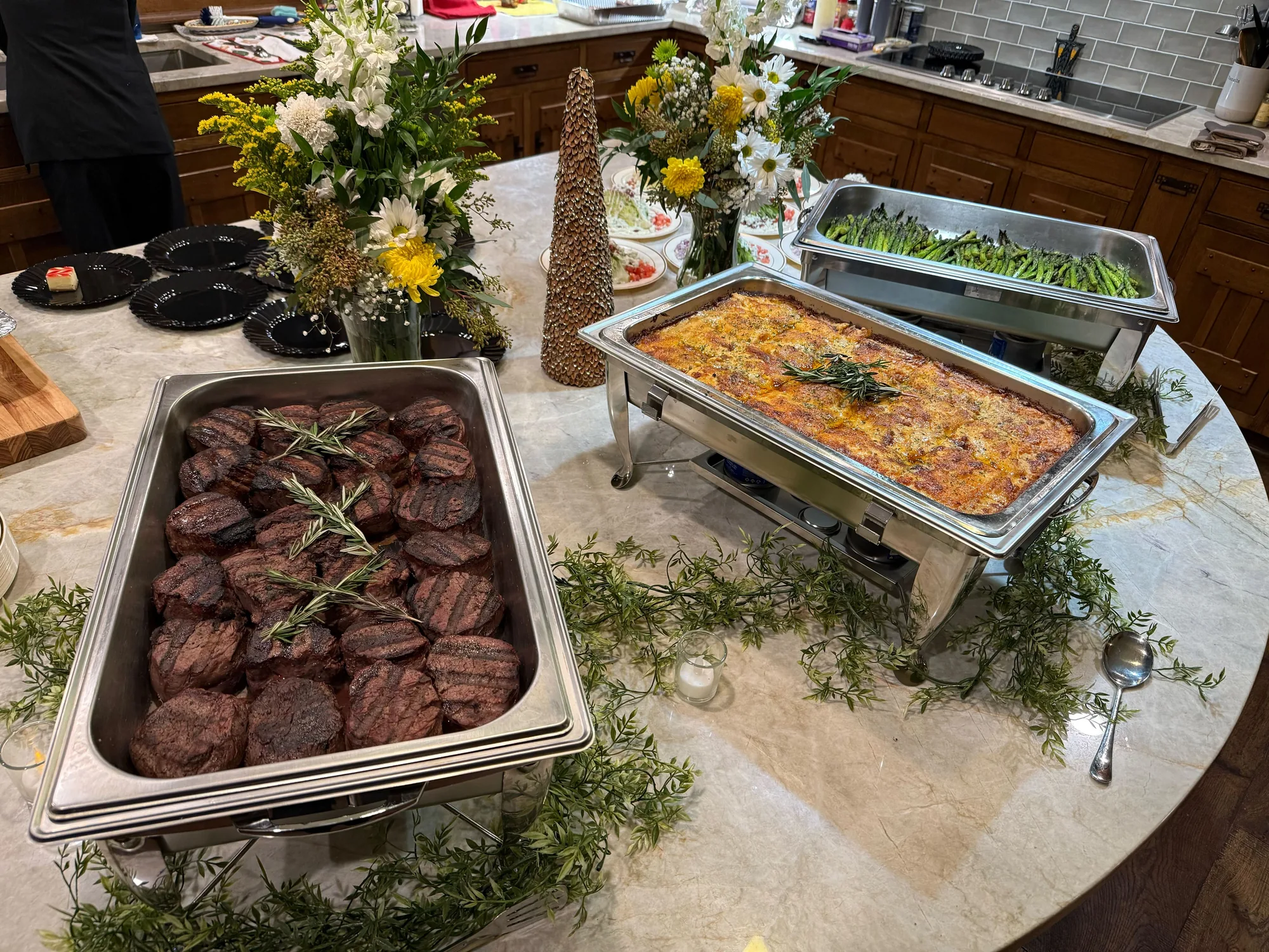 Indianapolis catering spread of grilled steaks, asparagus, and au gratin potatoes with floral centerpieces